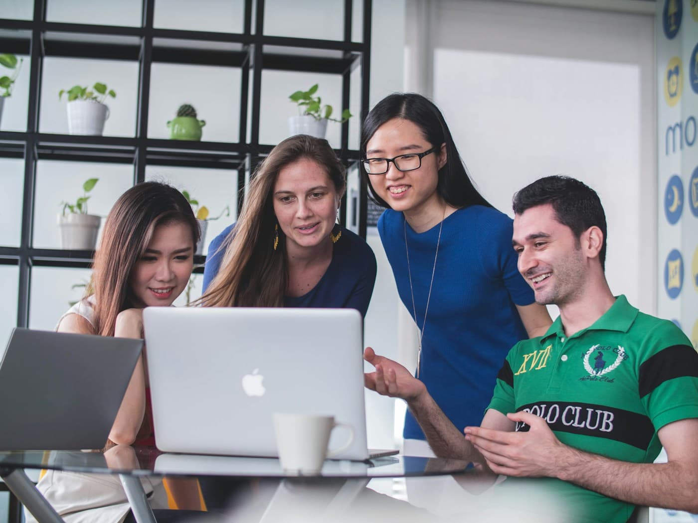 A team smiling around a laptop