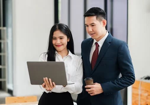 Two colleagues reviewing a laptop together
