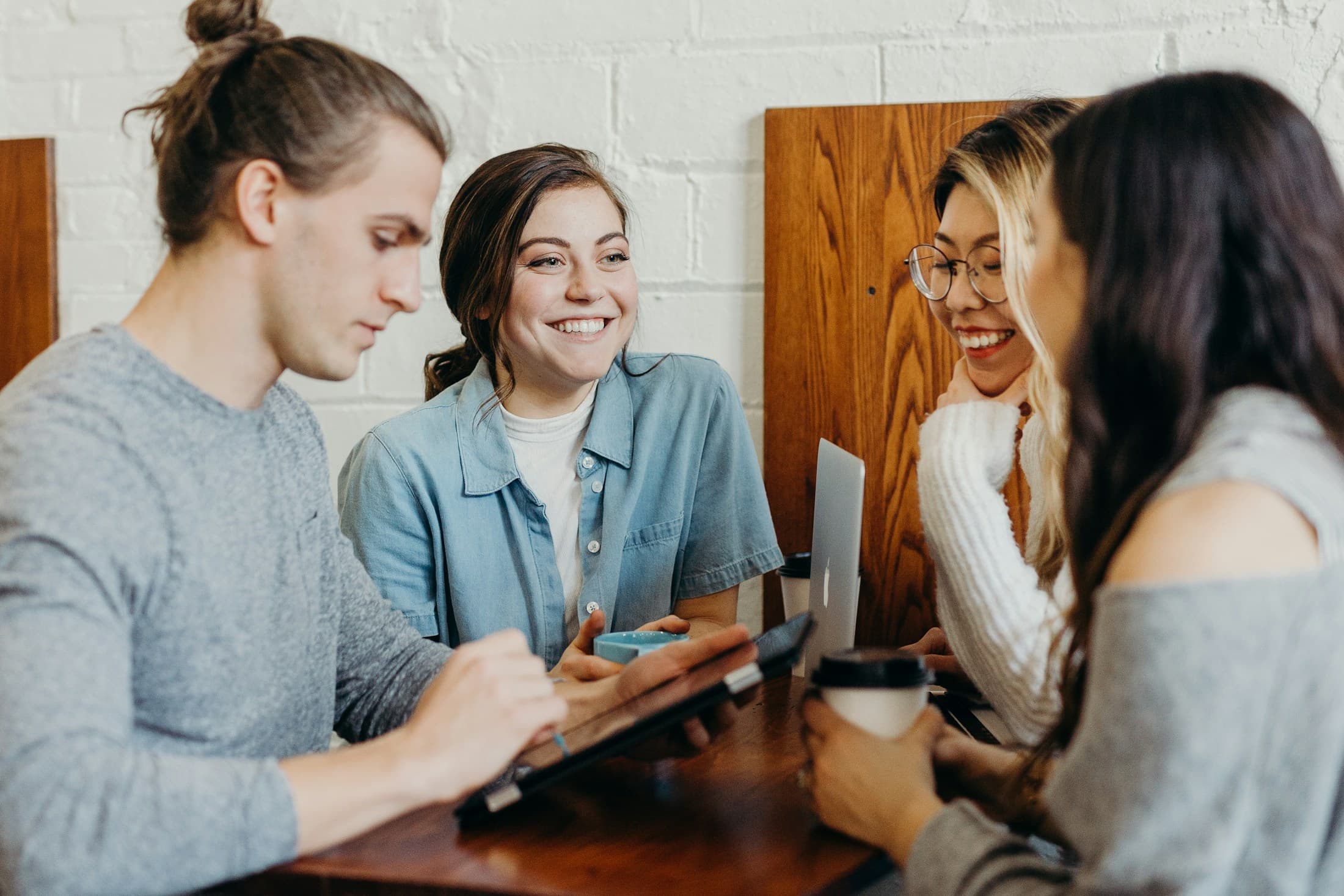 Friends talking and laughing around a café table